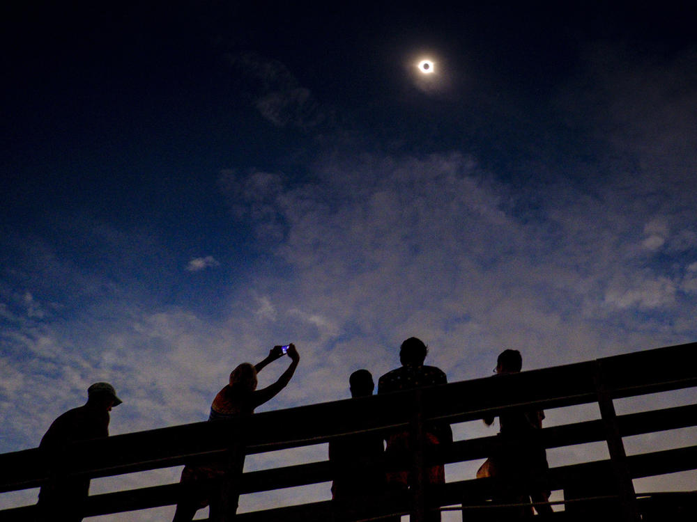 Eclipse gazers enjoying totality on August 21, 2017, in Isle of Palms, S.C. Eclipse experts say partial eclipses aren't nearly as dramatic.