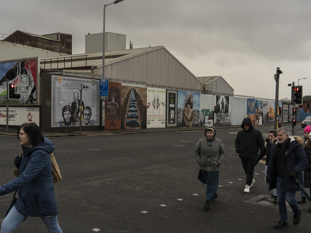 People walk by fresh murals in support of Palestinians at what's known as the International Wall or Solidarity Wall on the Falls Road in West Belfast, a prominently Catholic and Irish nationalist area of Northern Ireland, on Feb. 9.