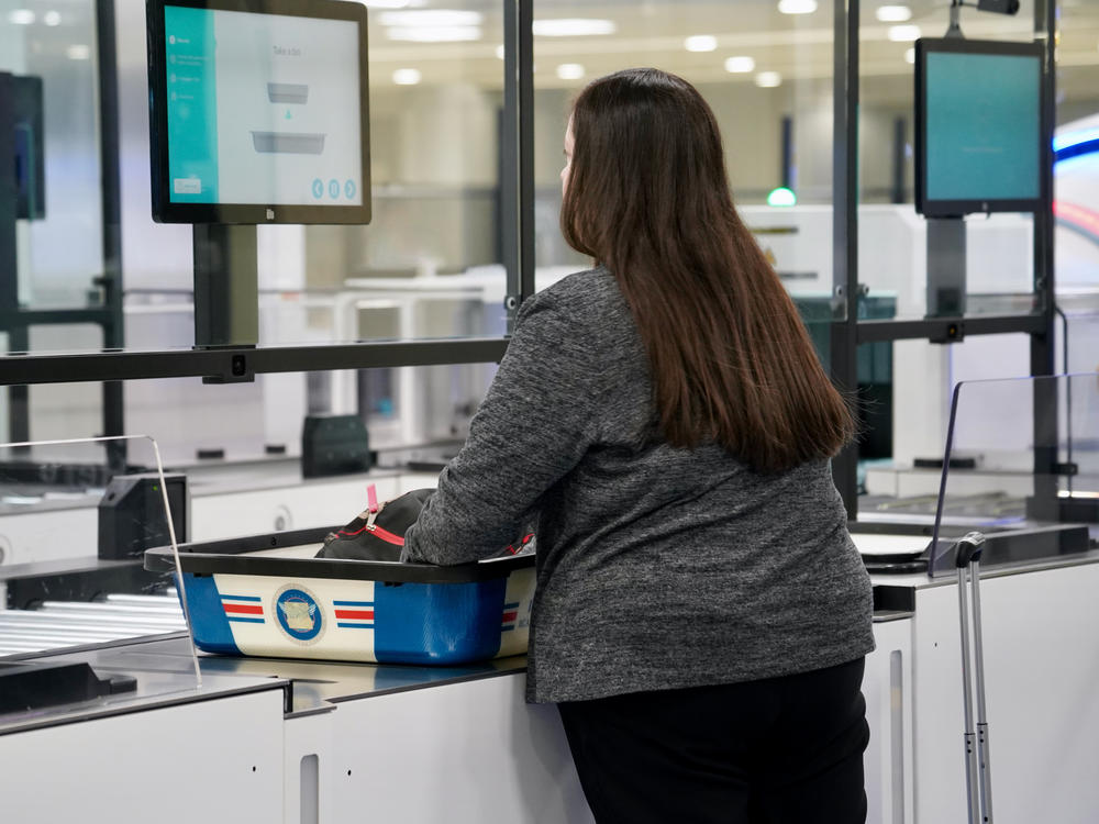 The new airport security prototype has a video monitor that provides step-by-step instructions for passengers to complete screening at their own pace.