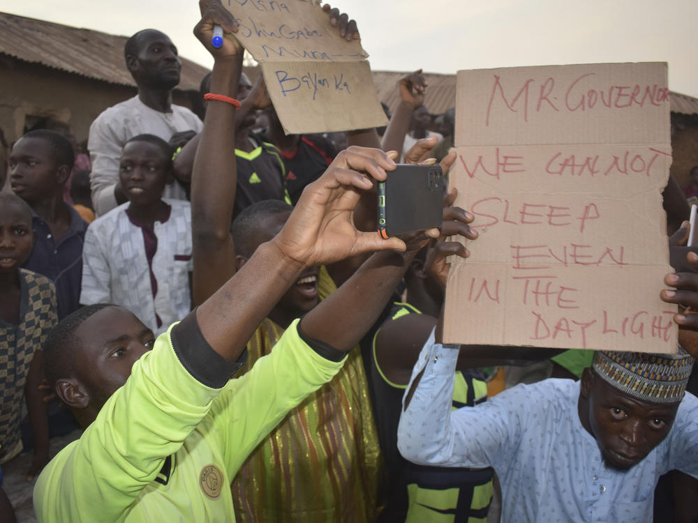 People gather around an area were gunmen kidnapped schoolchildren in Chikun, Nigeria, Thursday.