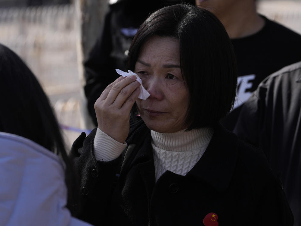 A woman cries as she meets other relatives of passengers on board the missing Malaysia Airline MH370 plane at a security cordon near the Malaysian embassy in Beijing, Friday, March 8, 2024.