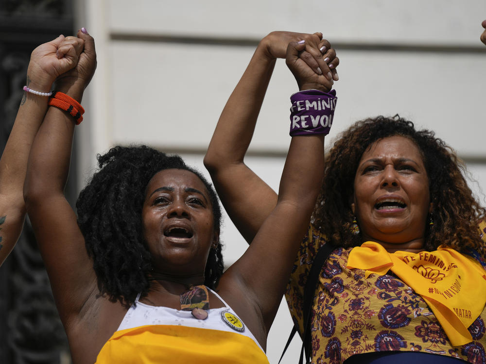 Demonstrators protest against femicide outside the City Council on International Women's Day in Rio de Janeiro.