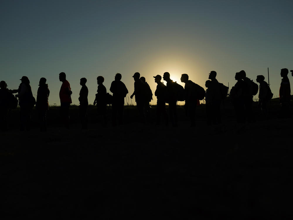 Migrants who crossed the Rio Grande and entered the U.S. from Mexico are lined up for processing by U.S. Customs and Border Protection on Sept. 23, 2023, in Eagle Pass, Texas. On March 8, 2024, a federal judge in Texas upheld a key piece of President Joe Biden's immigration policy that allows a limited number of migrants from four countries to enter the U.S. on humanitarian grounds.