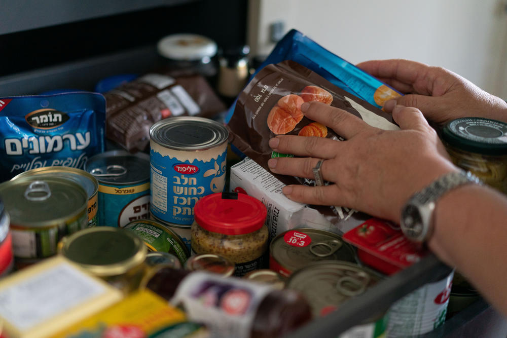 Neta Kahan, 52, shows the extra dried goods and canned foods her family bought in preparation for a possible war with Hezbollah in Lebanon, in her home in Rishpon, Israel.