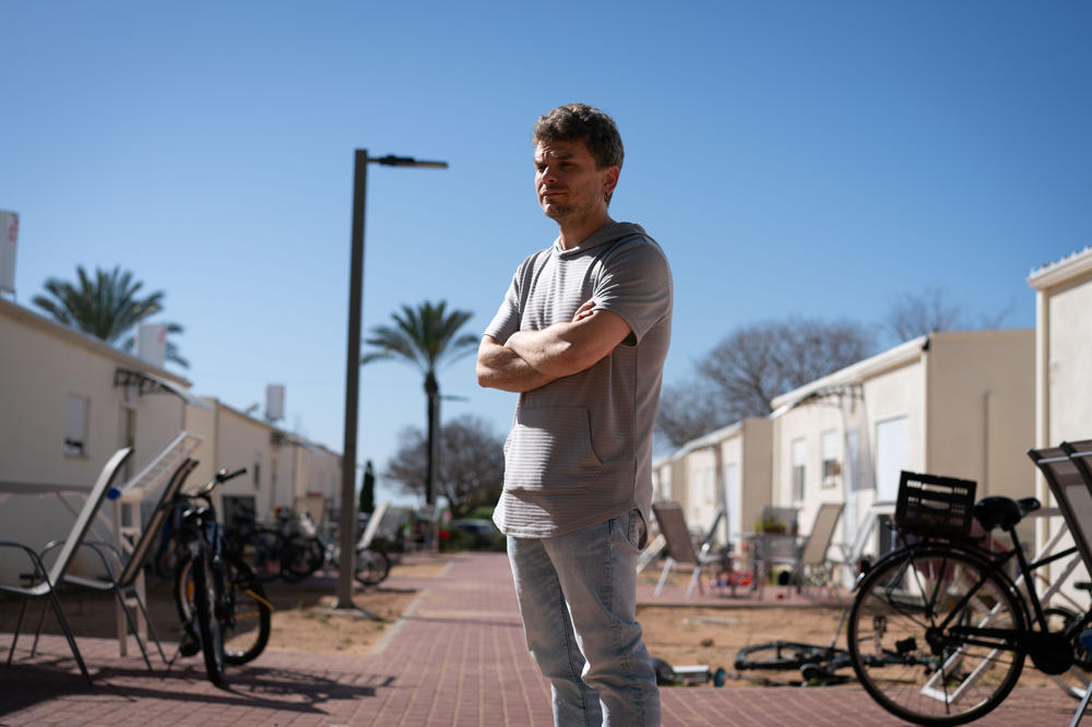 Avidor Schwartzman, 38, stands in front of a trailer park for survivors of the Oct. 7 attack, in Shefayim, Israel, on Tuesday. His family was moved from a hotel to one of these prefab homes two weeks ago. His wife's parents, Cindy and Igal Flash, were killed in the attack.