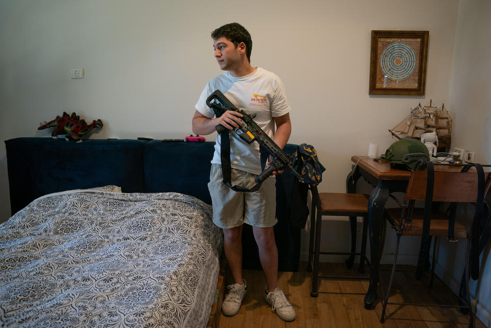 Ori Kahan, 21, in his bedroom in the central Israeli community of Rishpon. Kahan volunteers in his community's security squad. The group existed before the war, but since Oct. 7, it has received arms, protective gear and training from the police, and has been on a higher state of alert.