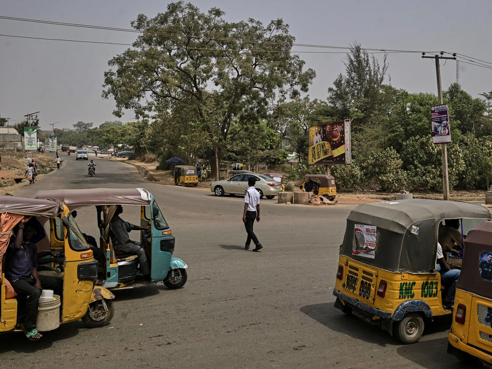 A traffic officer directs three-wheeled rickshaws, known as <em>keke Napep</em>, at Lokogoma Junction in Abuja, Nigeria, on Feb. 3.
