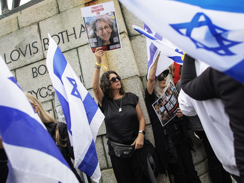 Supporters of the groups Hostages and Missing Families Forum and Bring Them Home Now hold portraits of missing and kidnapped Israeli girls and women during a demonstration outside the South African parliament in Cape Town to mark International Women's Day.