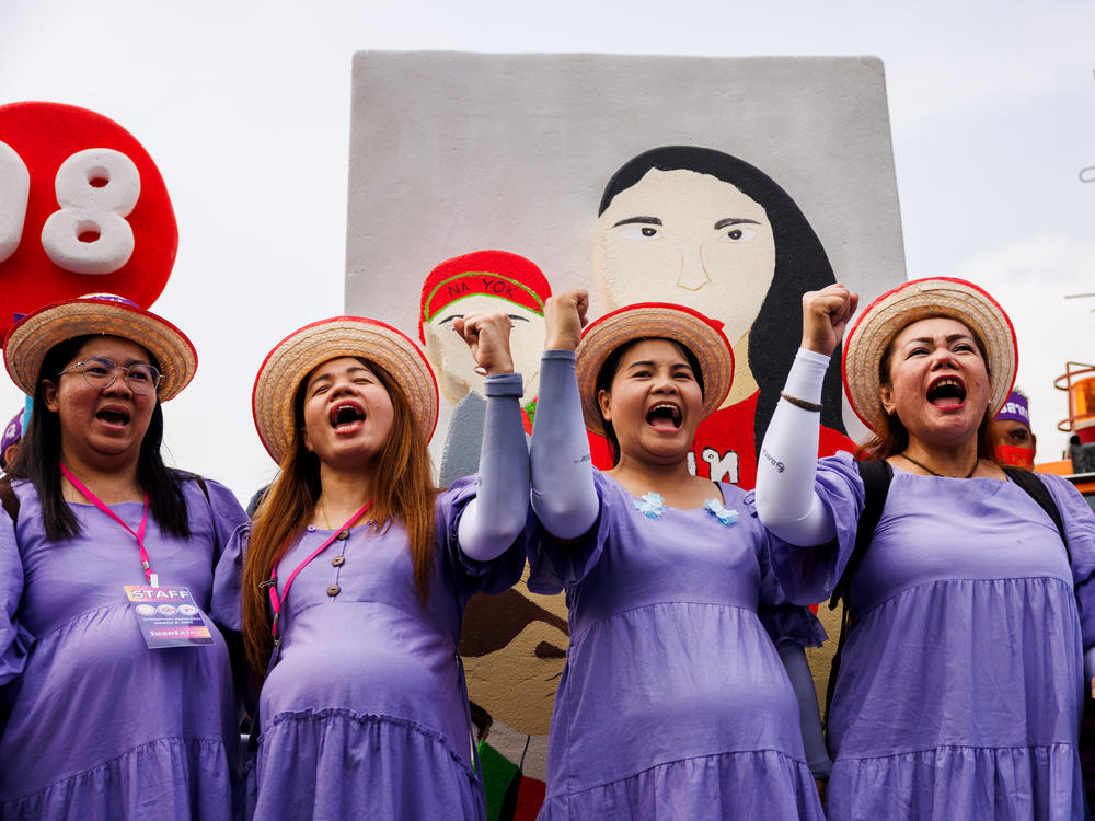 Members of Thai labor unions and women's networks  dressed in pregnancy costumes to march to Government House on International Women's Day to draw attention to maternity rights in Bangkok, Thailand.