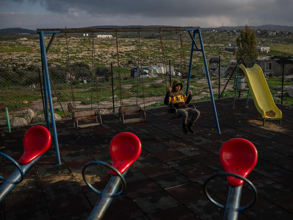 A boy sits on a swing in a playground in the Palestinian village of Susya in the occupied West Bank.