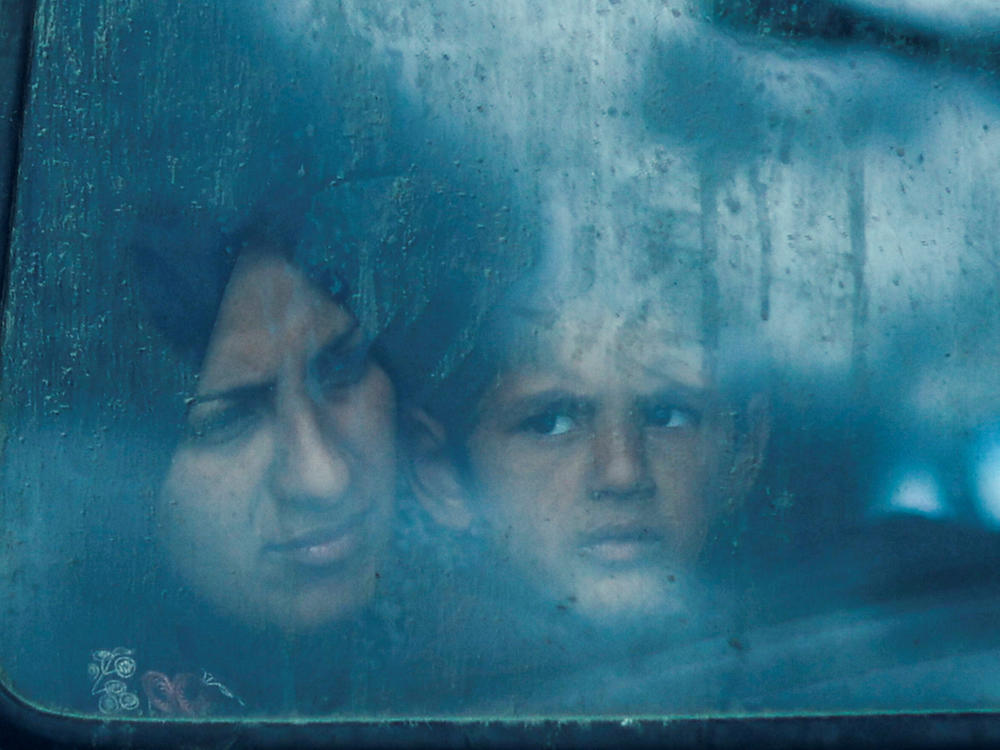 Displaced Palestinians look out from a bus window in Rafah on Saturday, March 9.