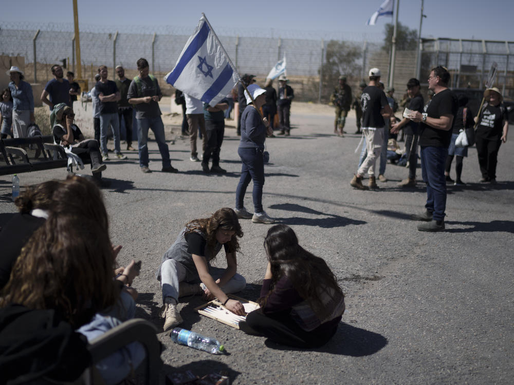 People gather at Israel's Nitzana border crossing with Egypt in southern Israel on Tuesday, March 5, protesting against the delivery of humanitarian aid to the Gaza Strip until all of the hostages being held by Hamas have been released.