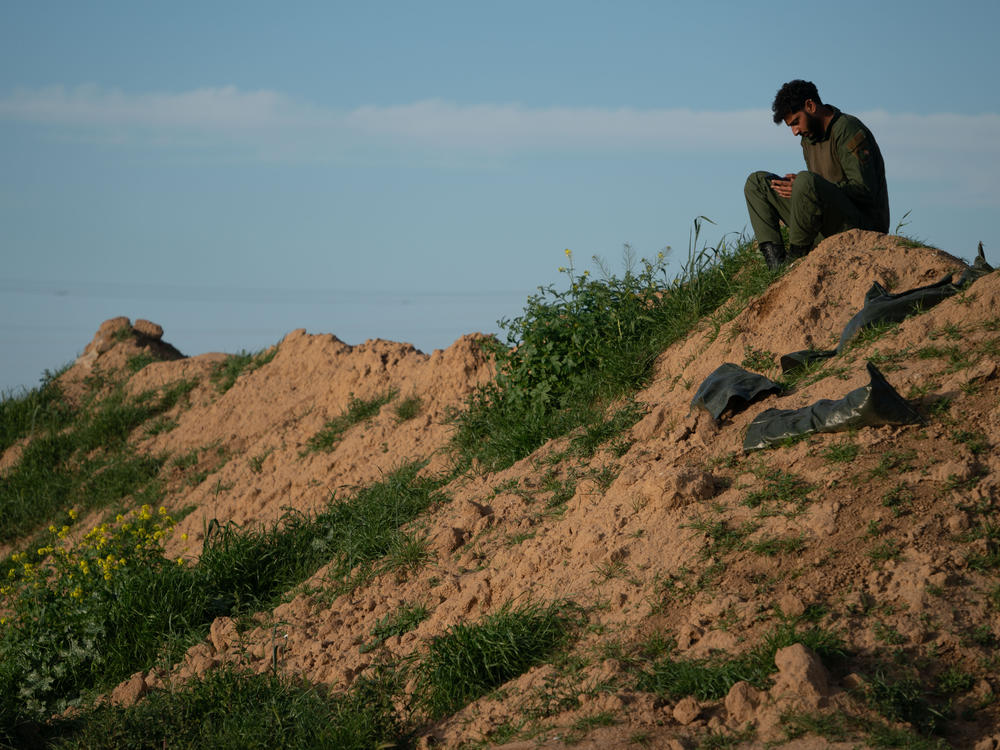 An Israeli soldier sits on a hill on Israel's southern border with the Gaza Strip on Thursday, March 7.