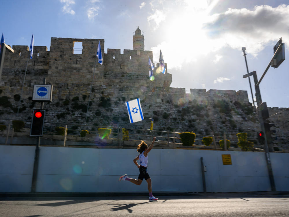 People participate in the 13th annual International Jerusalem Marathon on Friday, March 8, in Jerusalem. Many participants this year wore shirts and ran with signs raising awareness for the hostages kidnapped on Oct. 7 by Hamas and still being held in Gaza.