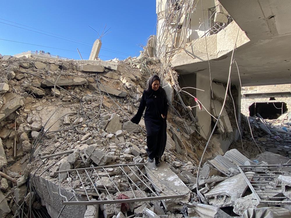 A woman looks through the remnants of an apartment building in Gaza on Saturday, March 9.