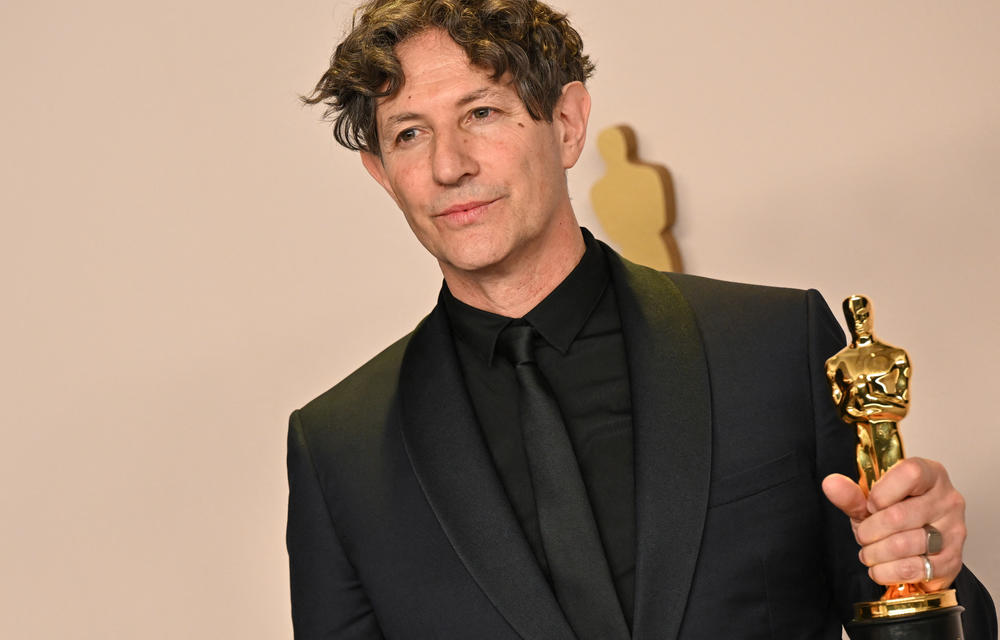 Jonathan Glazer poses in the press room with the Oscar for best international feature film for <em>The Zone of Interest.</em>