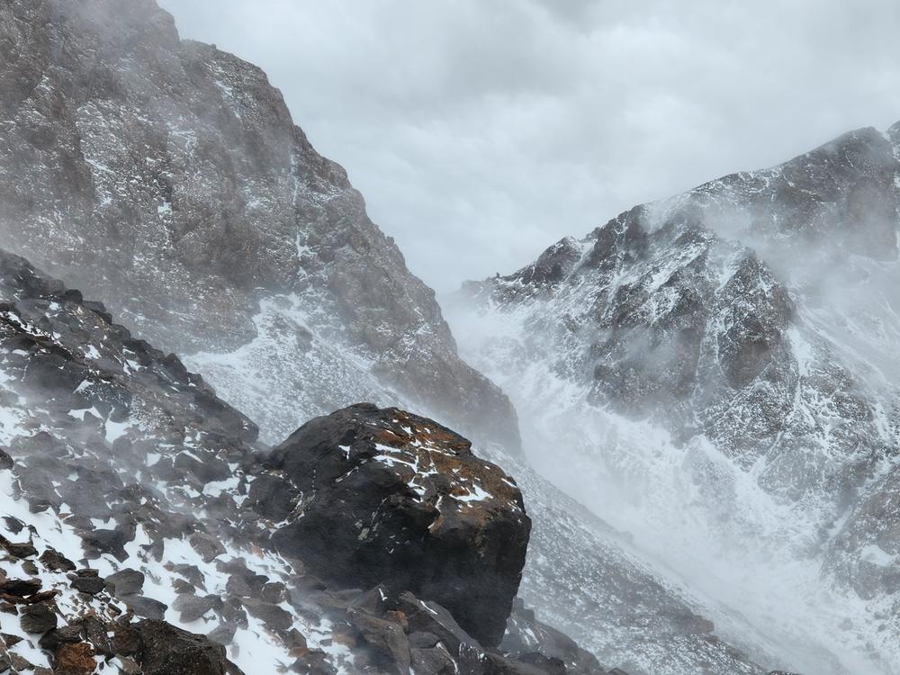 Climbing through a blizzard on the shoulder of Toubkal, the wind is so fierce it nearly knocks us off our feet.