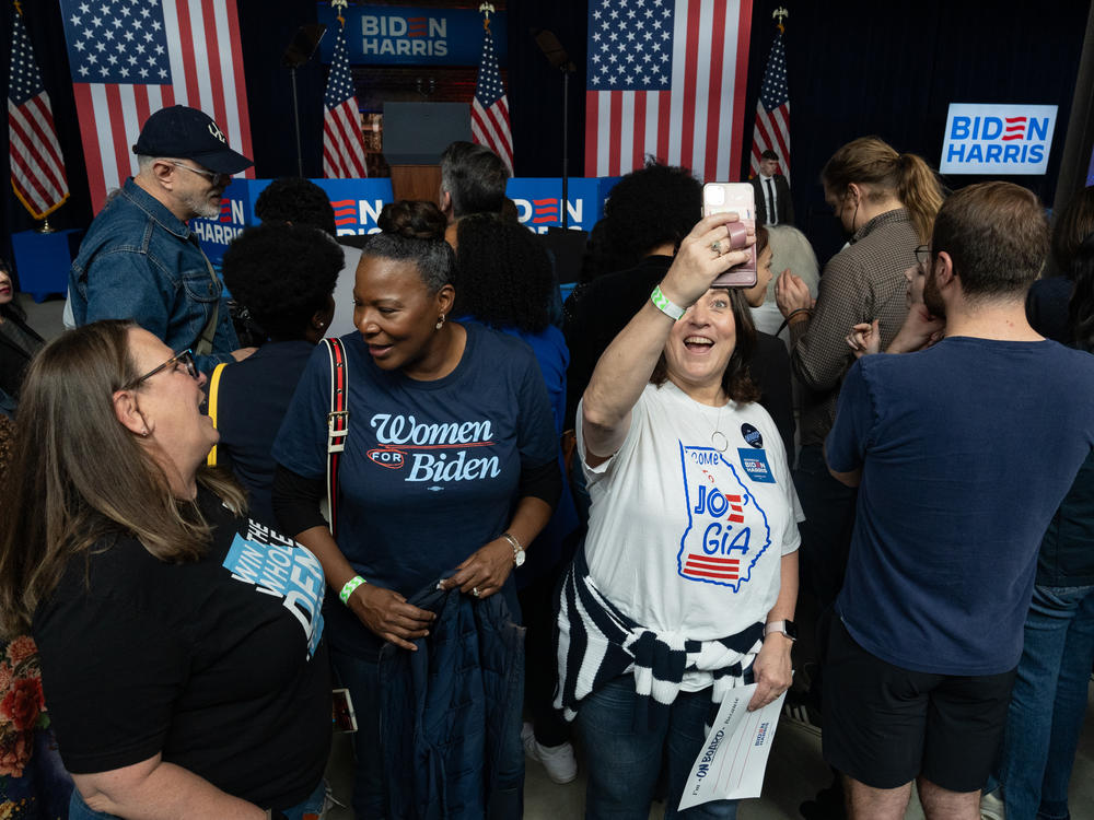 Paula Benson, in white, attended a rally for President Joe Biden in Atlanta and hopes voters aren't complacent in November.