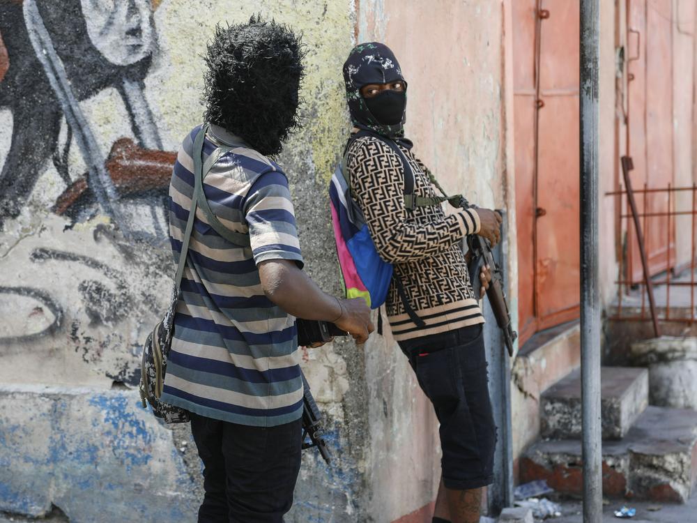 Members of the G9 and Family gang speak to each other while standing guard at their roadblock in the Delmas 6 neighborhood of Port-au-Prince, Haiti, Monday, March 11, 2024.