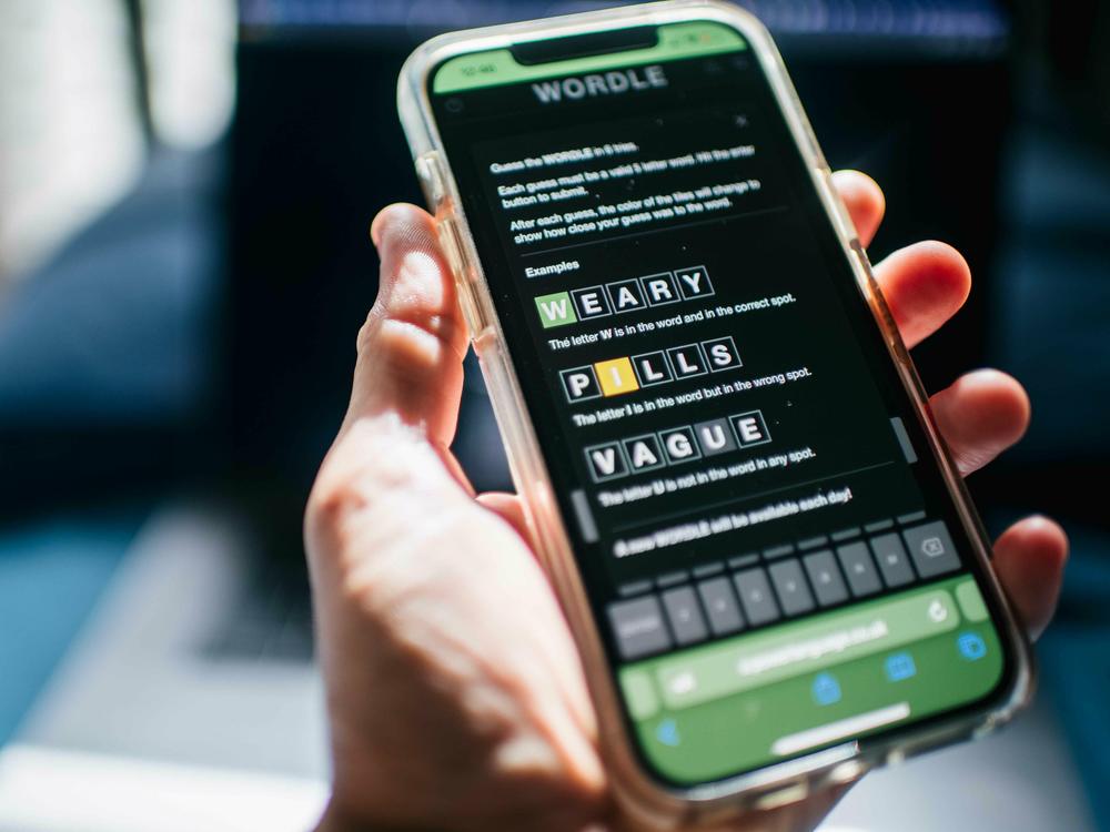 The word game Wordle is shown on a mobile phone in 2022. The <em>New York </em><em>Times </em>is accusing some Wordle clone creators of copyright infringement violations.