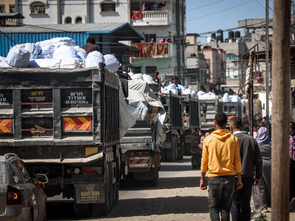 Trucks carrying humanitarian aid make their way along a street in Rafah in the southern Gaza Strip.