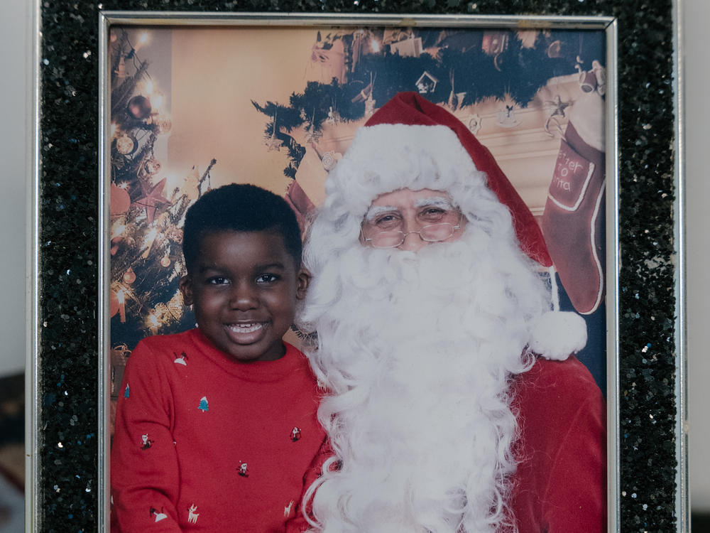 A photograph of Angie Atkins' 7-year-old son, A.J., with Santa Claus. Atkins sold her car to save money, but she still struggled to pay for food and rent before she was picked for a cash aid program.