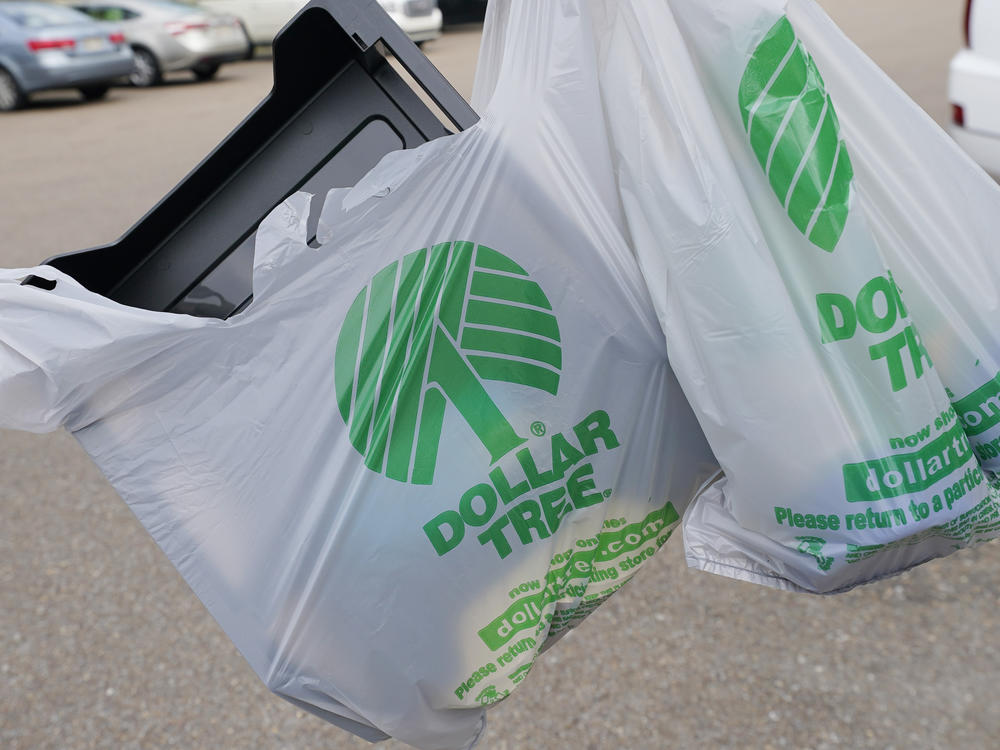 A customer exits a Dollar Tree store holding a shopping bag on Wednesday, May 11, 2022, in Jackson, Miss.