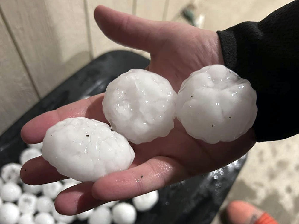 In this image provided by Jeremy Crabtree, large chunks of hail are shown Wednesday night, in Shawnee, Kan. Volatile weather honed in on parts of Kansas and Missouri, with some storms dumping massive chunks of hail.