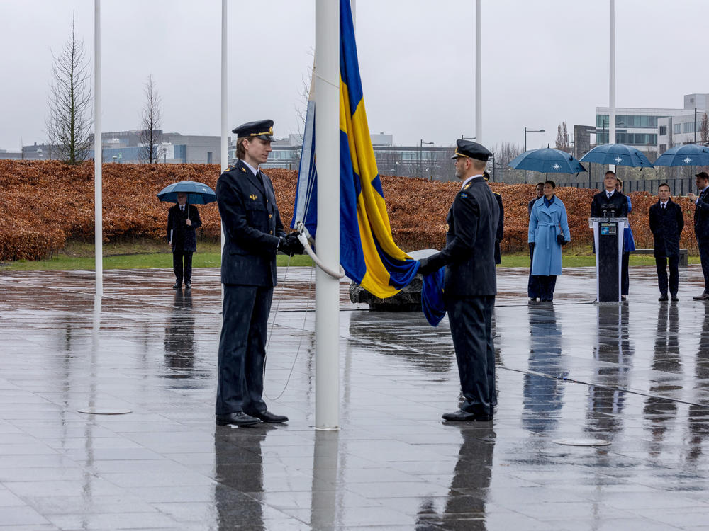 Military personnel raise the Swedish flag during Sweden's NATO accession ceremony at NATO headquarters during a flag-raising ceremony outside NATO headquarters this week.  Expanding the number of NATO members is one way the military alliance is trying to strengthen itself after Russia's invasion of Ukraine.