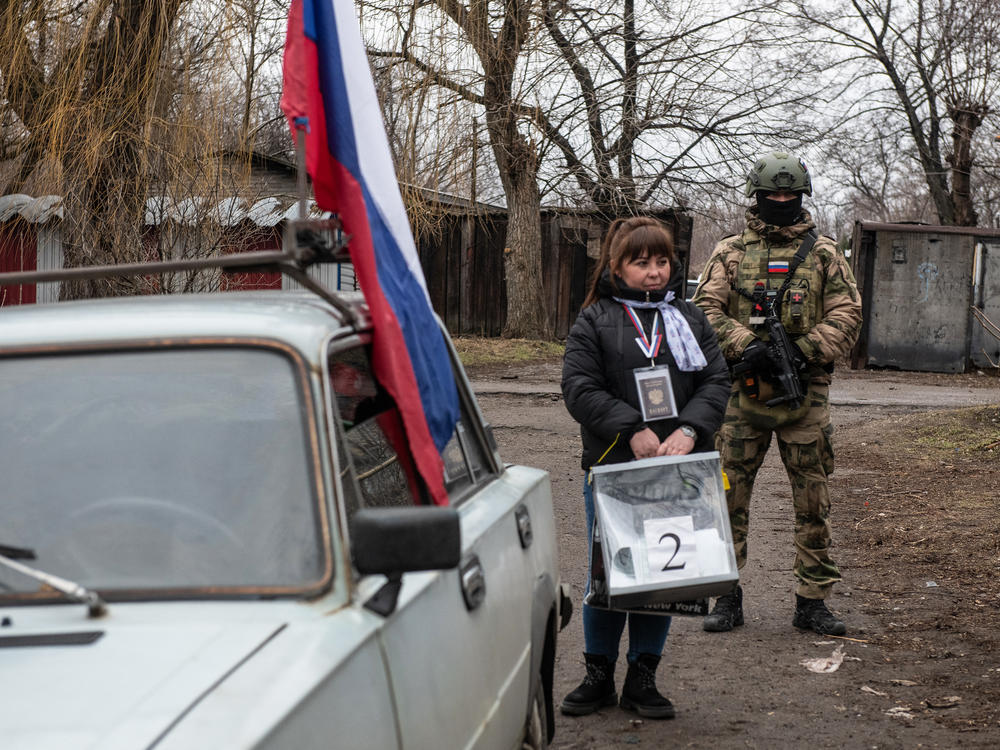 A member of a local election commission, accompanied by a serviceman, visits voters during early voting in Russia's presidential election, in Donetsk, in Russian-controlled Ukraine, amid the Russia-Ukraine conflict on Thursday.