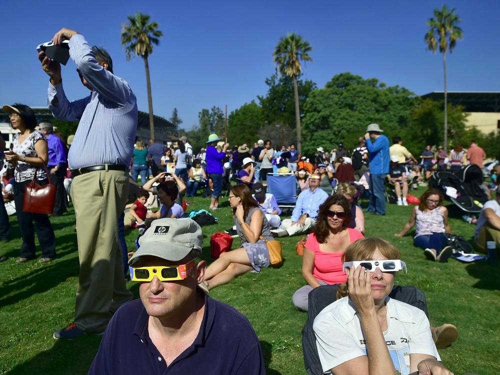Eclipse enthusiasts wearing protective glasses view a partial eclipse from Beckman Lawn at Caltech in Pasadena, Calif., on Aug. 21, 2017. Another solar eclipse is just weeks away.