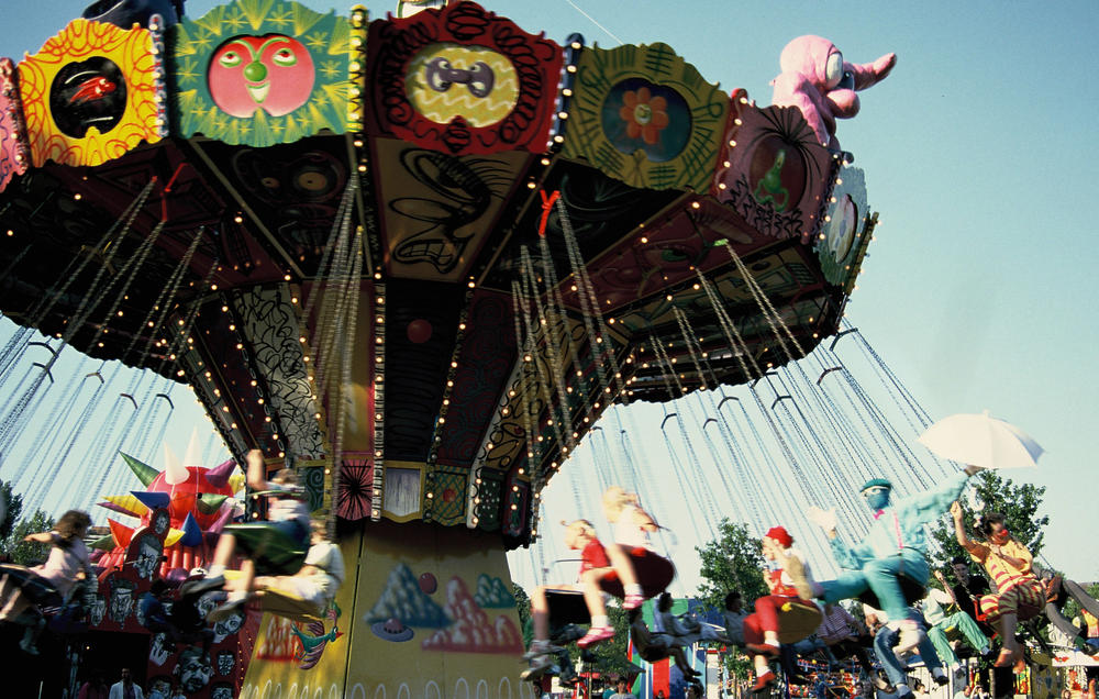 Visitors ride on Kenny Scharf's painted swing ride in 1987.
