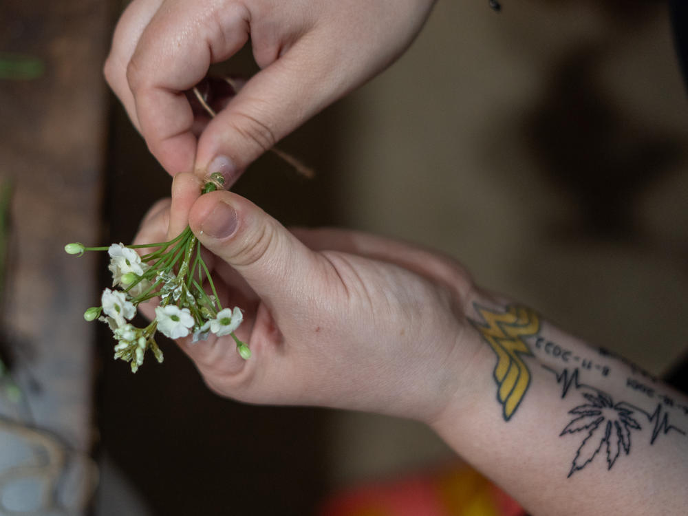 Bridget Barton works on a corsage for a family member's wedding at home in Osawatomie, Kan. Barton now uses arts and crafts projects as a therapeutic way to deal with the trauma she experienced during the shootings at the Super Bowl parade in Kansas City, Mo.