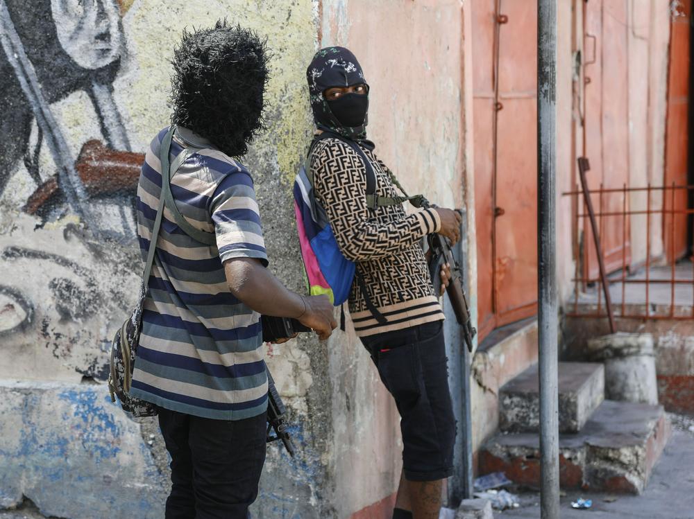 Members of the G9 and Family gang speak to each other while standing guard at their roadblock in the Delmas 6 neighborhood of Port-au-Prince, Haiti, on Monday.