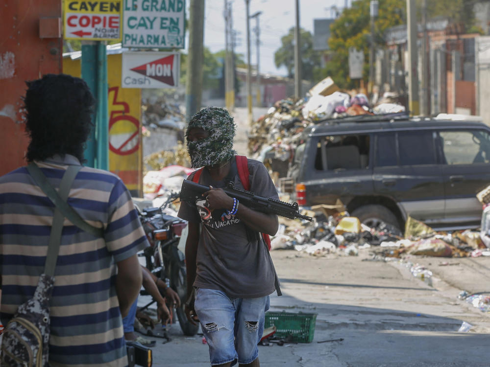Armed members of the G9 and Family gang stand guard at their roadblock in the Delmas 6 neighborhood of Port-au-Prince, Haiti, Monday.