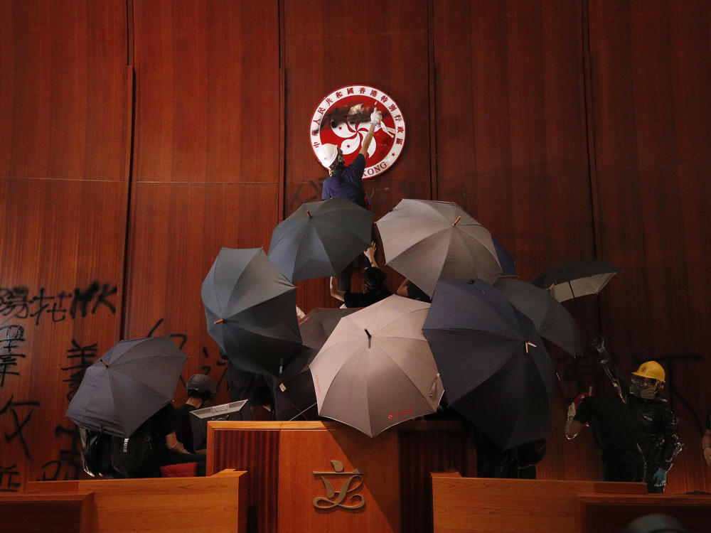 Protesters deface the Hong Kong logo at the Legislative Council to protest against the extradition bill in Hong Kong on July 1, 2019.