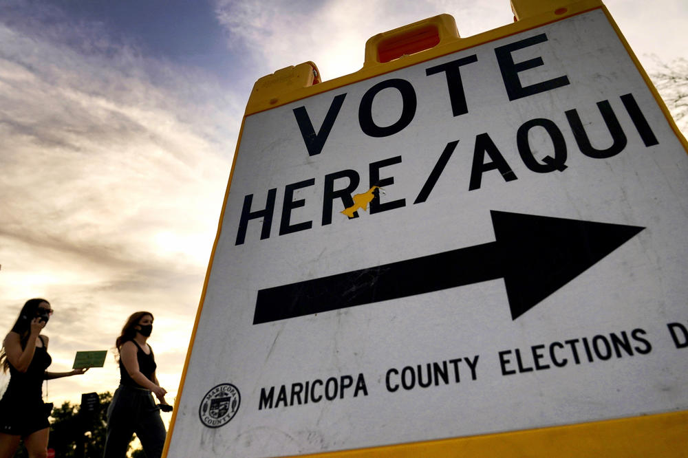 In this file photo, voters deliver their ballot to a polling station in Tempe, Ariz., on Nov. 3, 2020. In the 2024 presidential preference election in Arizona, independent voters are not permitted to vote.