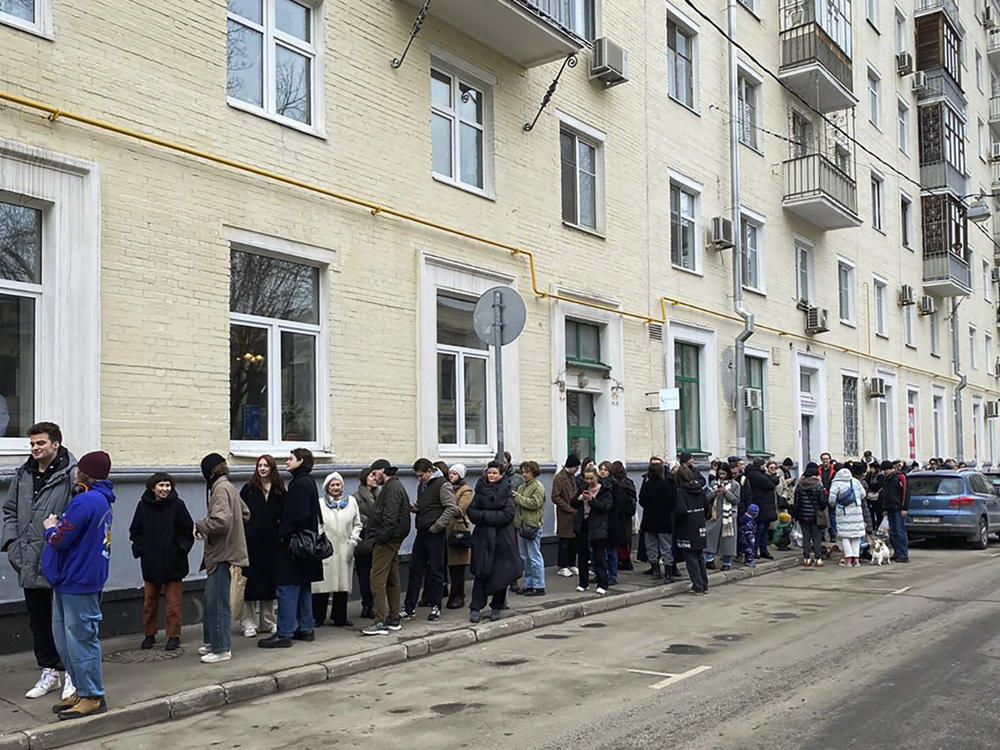 Voters queue at a polling station in Moscow on Sunday. The Russian opposition called on people to head to polling stations at noon on Sunday in protest as voting takes place on the last day of an election that is all but certain to extend President Vladimir Putin's rule. The AP can't confirm that all the voters seen at the polling station at noon were taking part in the opposition protest.