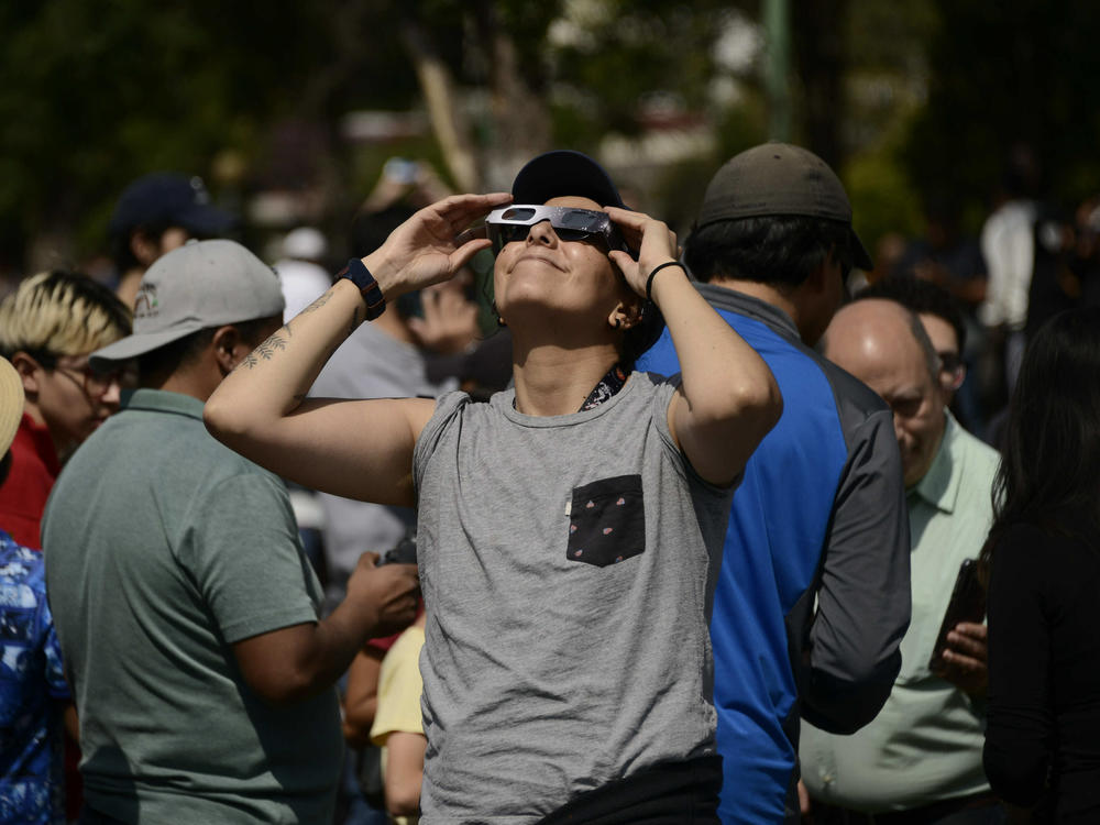 A woman watches an annular solar eclipse on October 14, 2023 using special solar filter glasses at the National Autonomous University of Mexico.