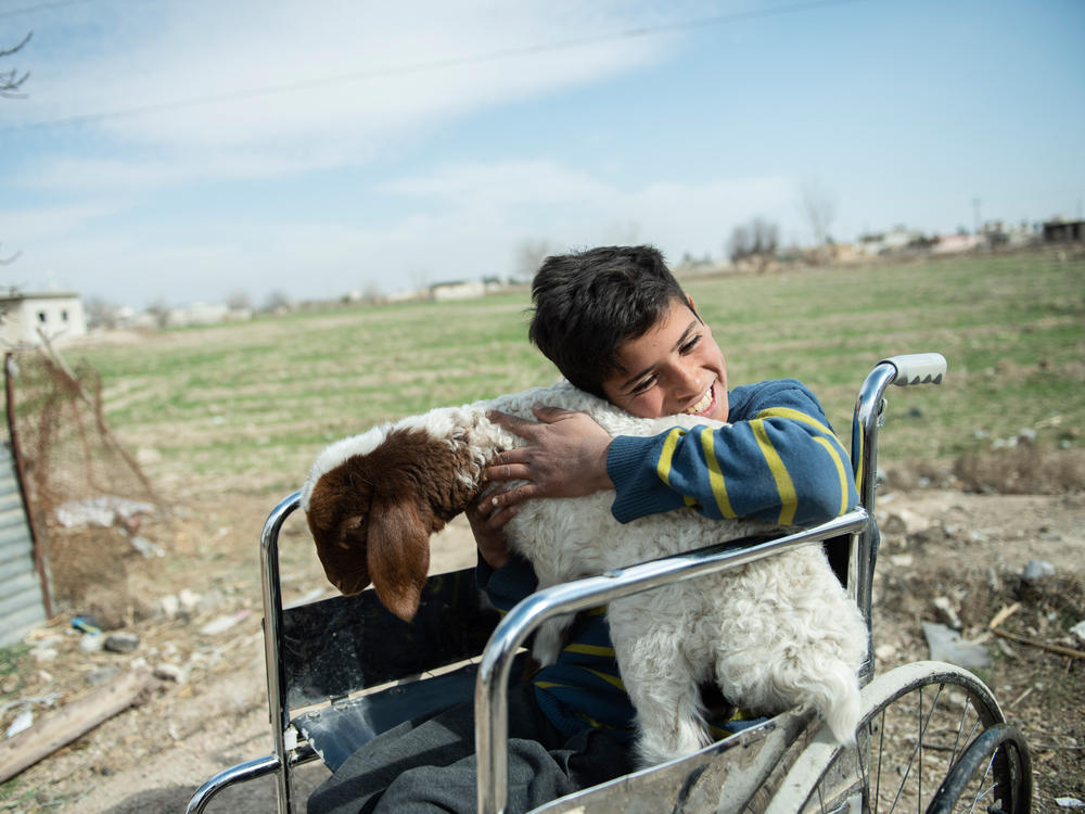 Azzam, 12, lost his leg when a bomb hit the building where he was sheltering with his family in Syria. They now live in a rural area outside of Damascus, where he finds happiness and peace in caring for the farm animals after school. The photo is from Feb. 21, 2022.