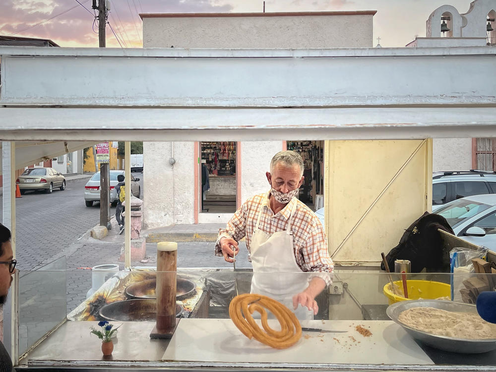 Martin Elizalde Valenzuela paints houses in the morning and is happy to sell his churros in the afternoon. The photo was taken in Jalisco, Mexico, on Dec. 26, 2022.