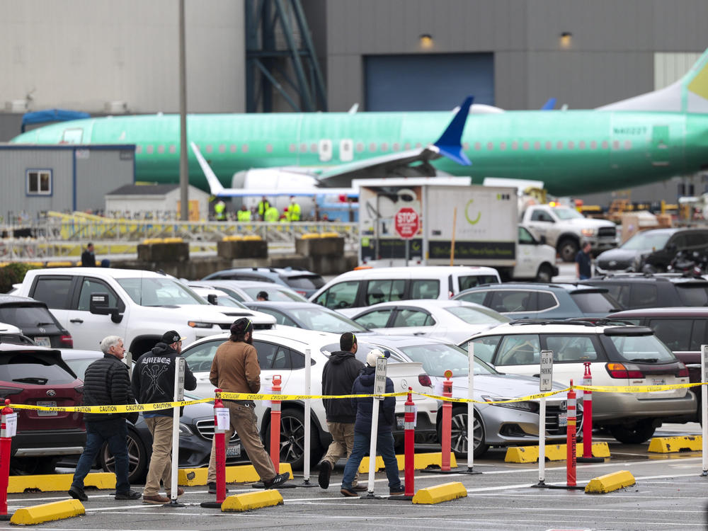 Workers and an unpainted Boeing 737 aircraft are pictured as Boeing's 737 factory teams hold the first day of a 