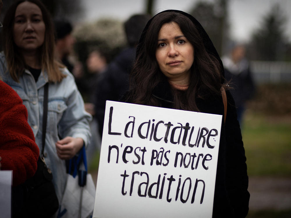 A woman holds a placard reading dictatorship is not our tradition during a gathering of Navalny supporters near the Russian Embassy in Paris on Sunday, during Russia's presidential election.