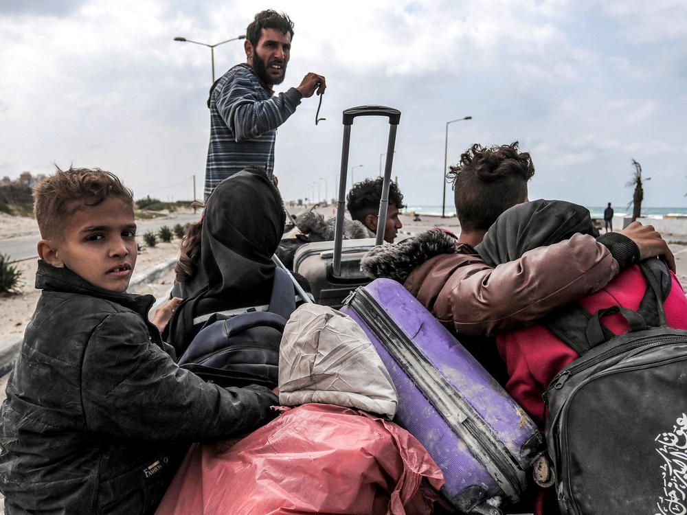 Displaced Palestinians fleeing from the area in the vicinity of Gaza City's al-Shifa hospital ride on a donkey-drawn cart as they arrive at the Nuseirat refugee camp in the central Gaza Strip on Monday.