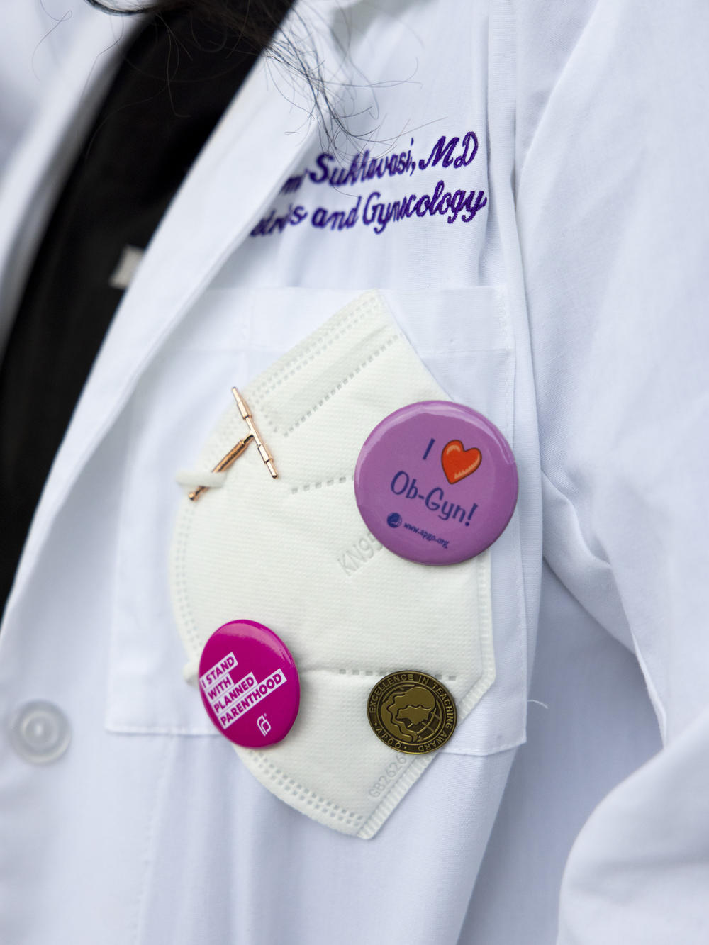 Pins on Dr. Neelima Sukhavasi's coat pocket show her support for women's reproductive health, Baton Rouge, La., on Monday, March 18, 2024.