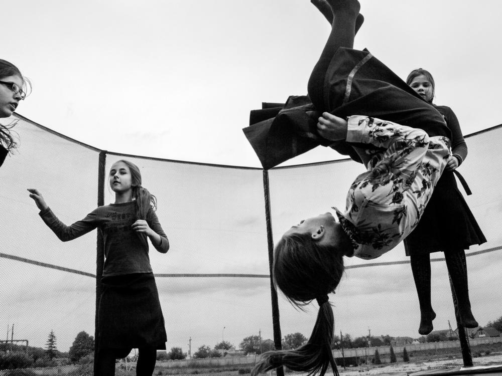 Girls play on a trampoline in 2016 during a break between classes in the village of Anatevka, Ukraine. They're among the thousands of Ukrainians who fled their homes after the annexation of Crimea by Russia in 2014.