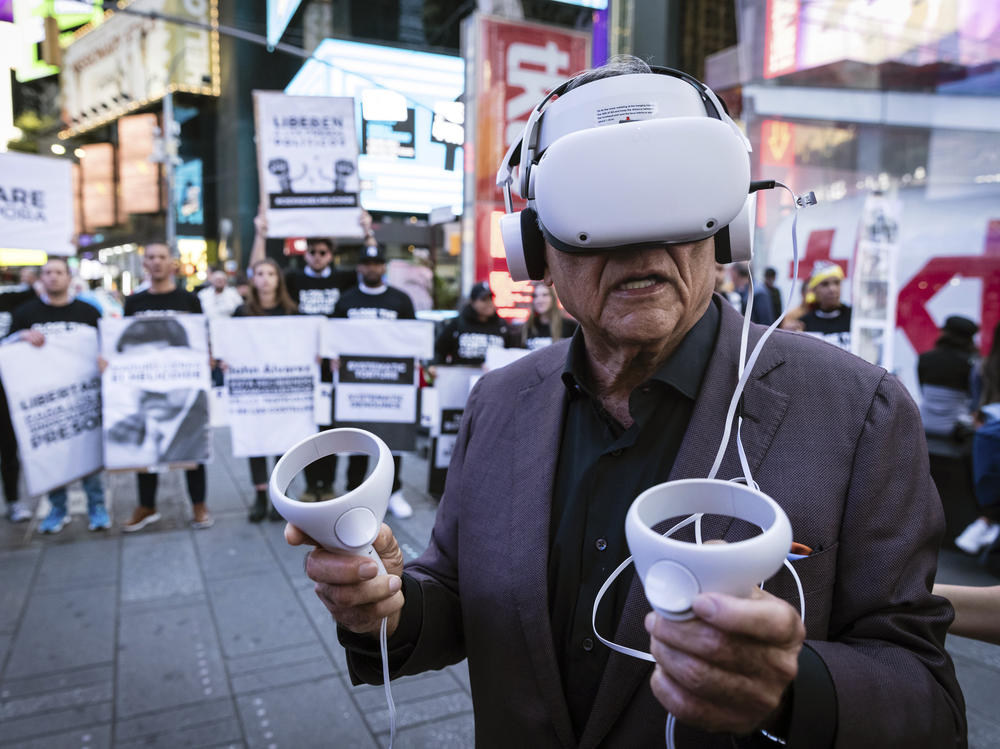 A person standing near Times Square in New York City wears a virtual reality headset screening an immersive experience of the conditions at Venezuela's El Helicoide prison, on Sept. 19, 2023. Protesters gathered to demand the release of political prisoners and the closure of the detention center over allegations of torture.