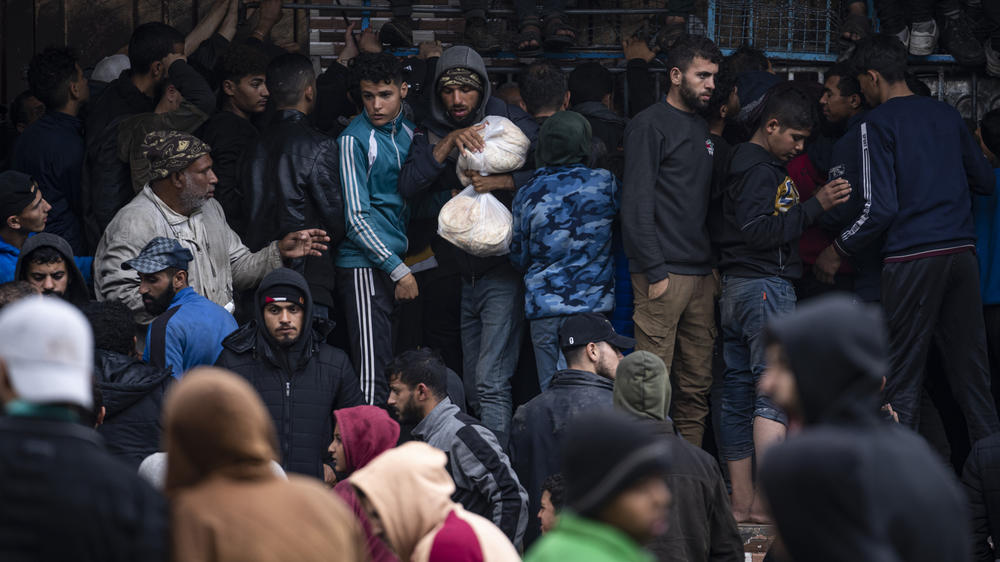 Palestinian crowds struggle to buy bread from a bakery in Rafah, Gaza Strip, Sunday, Feb. 18.