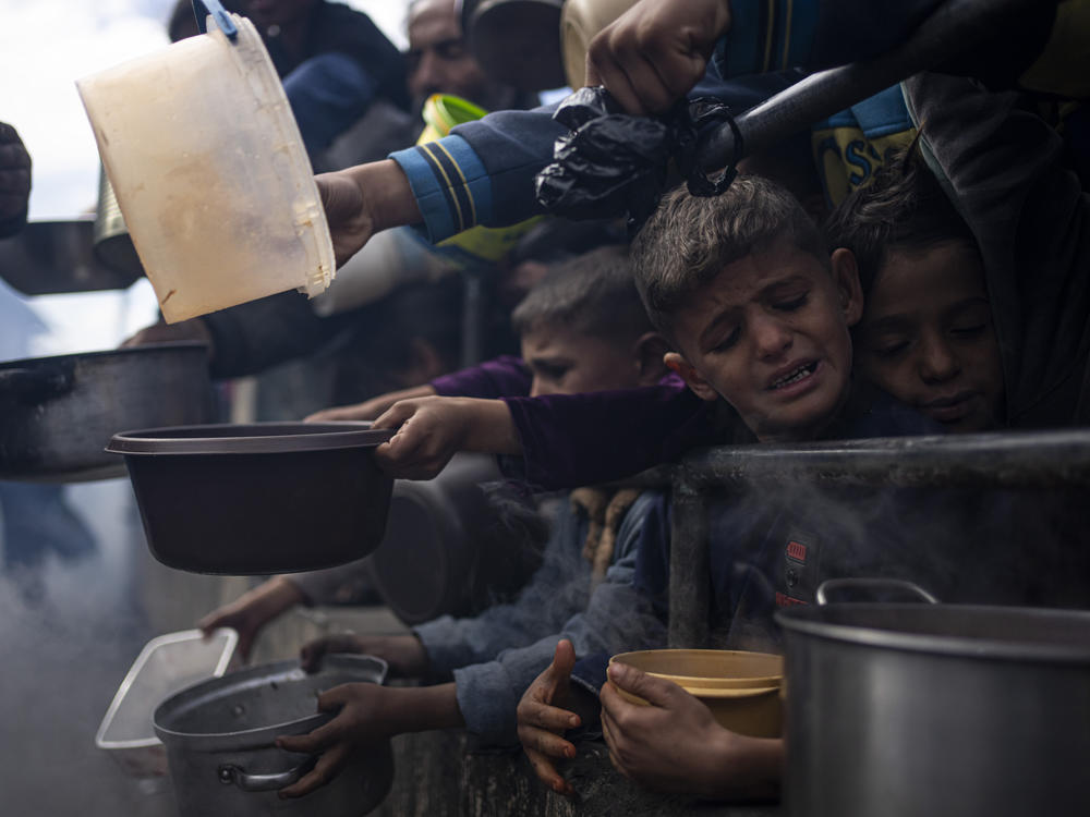 Palestinians line up for a free meal in Rafah, Gaza Strip, Friday, Feb. 16, 2024.
