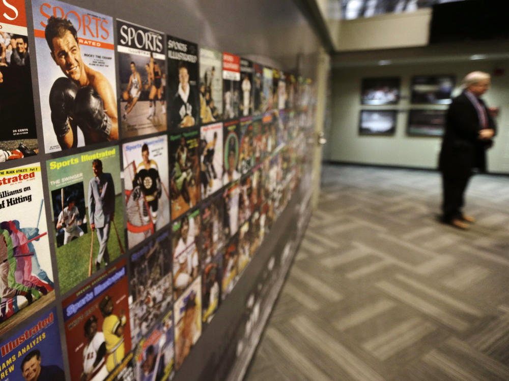 The Sports Museum curator Richard Johnson, right, stands near an exhibit that displays cover photos from the sports magazine Sports Illustrated in the museum at the TD Garden, in Boston.